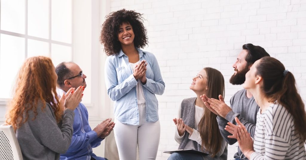 Gratitude in practice with people clapping for woman in the center